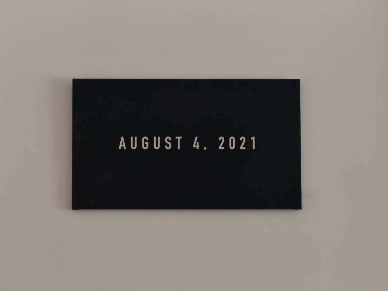 十方咖啡墙上的黑色日期牌，写着 AUGUST 4, 2021